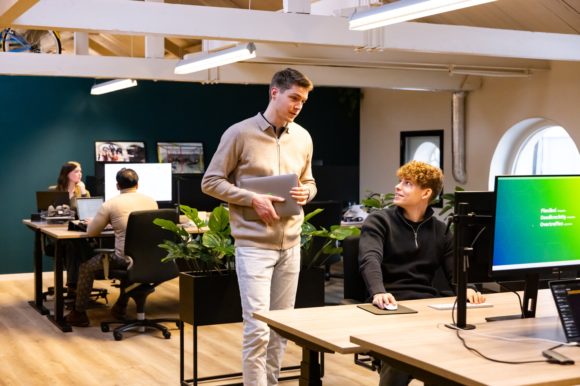 Werkoverleg bij een scherm op de kantoorvloer van Succesfactor