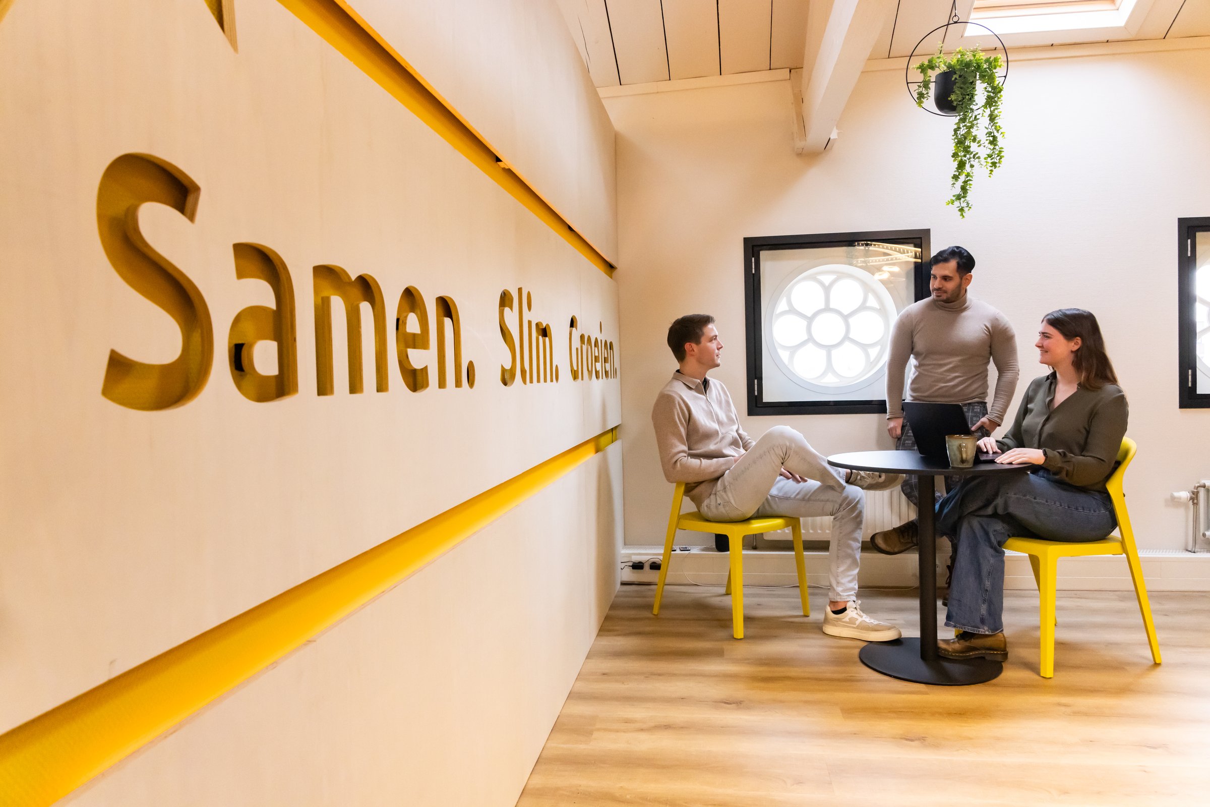 Werkoverleg bij Succesfactor: drie teamleden in gesprek aan tafel
